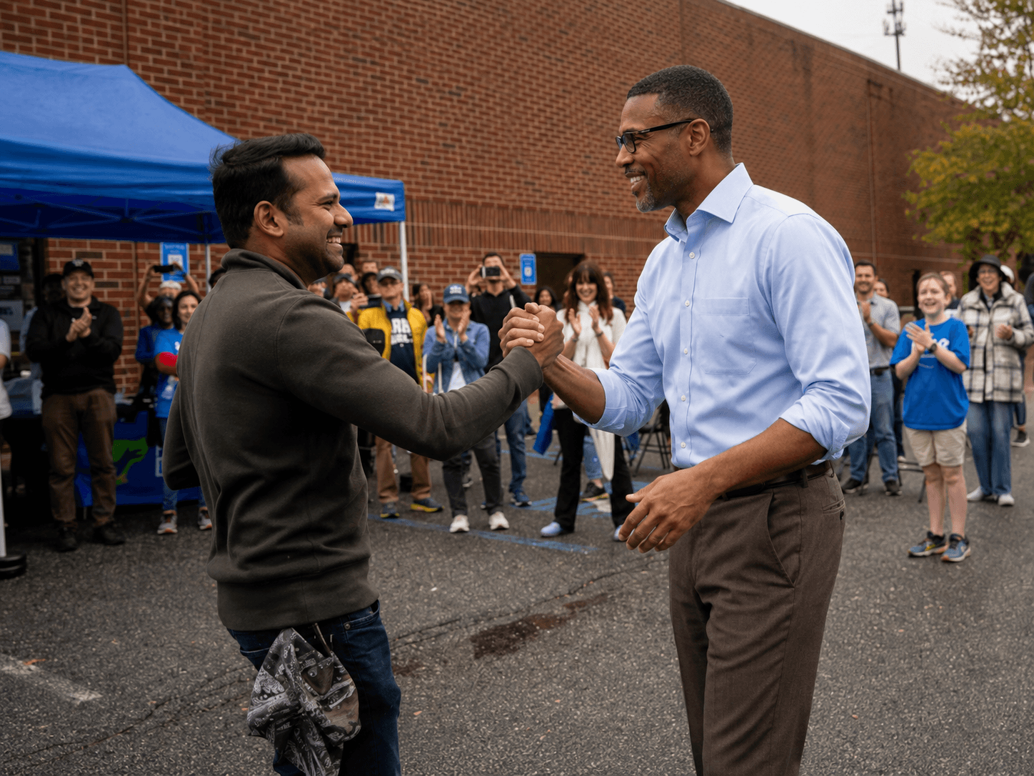 Solomon Price greeting a supporter at a campaign event as volunteers cheer